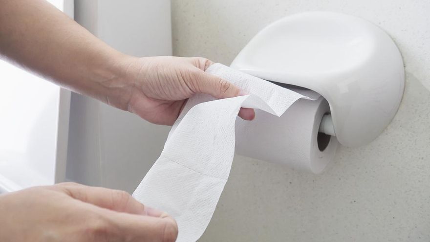 Lady pulling tissue in toilet